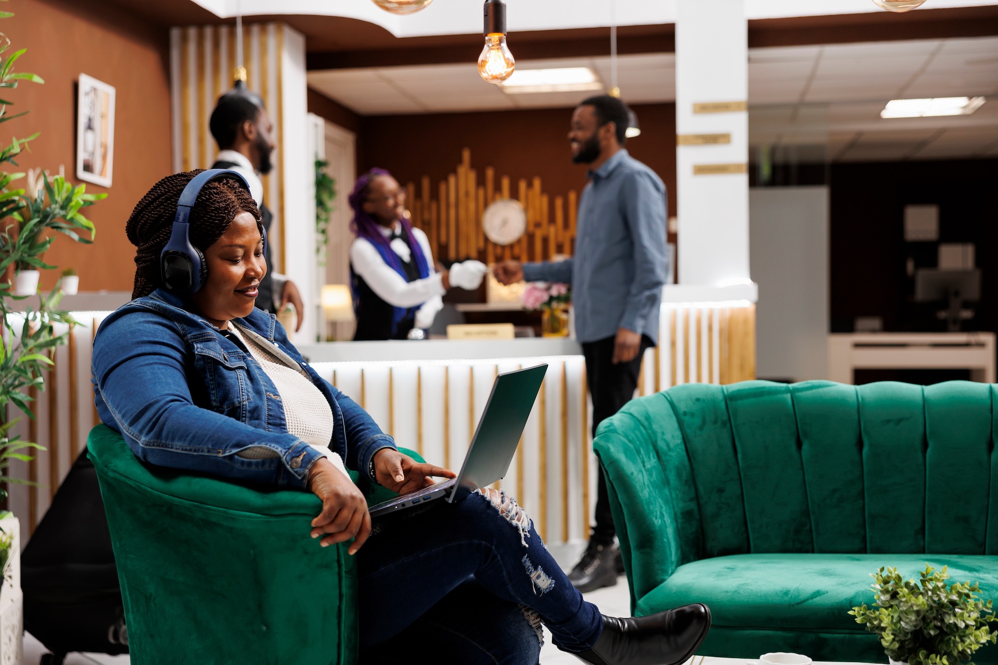 Woman resting in hotel lobby with laptop using free guest wifi