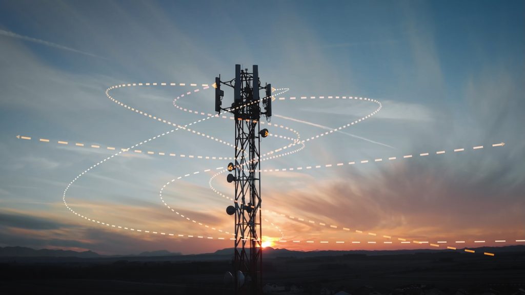 Sunset view of a 6G internet station tower with a 3D graphic overlay of signal waves emitted from antennas